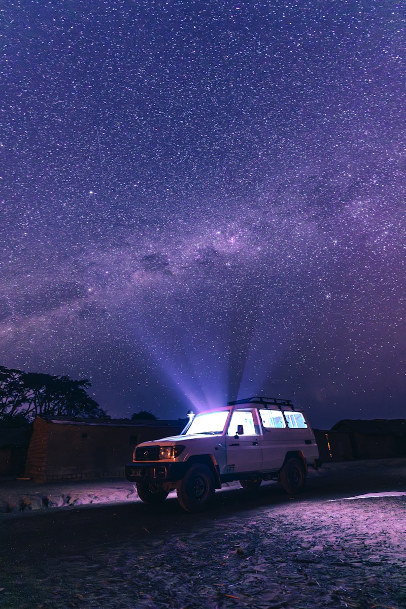 A truck parked under a night sky filled with stars