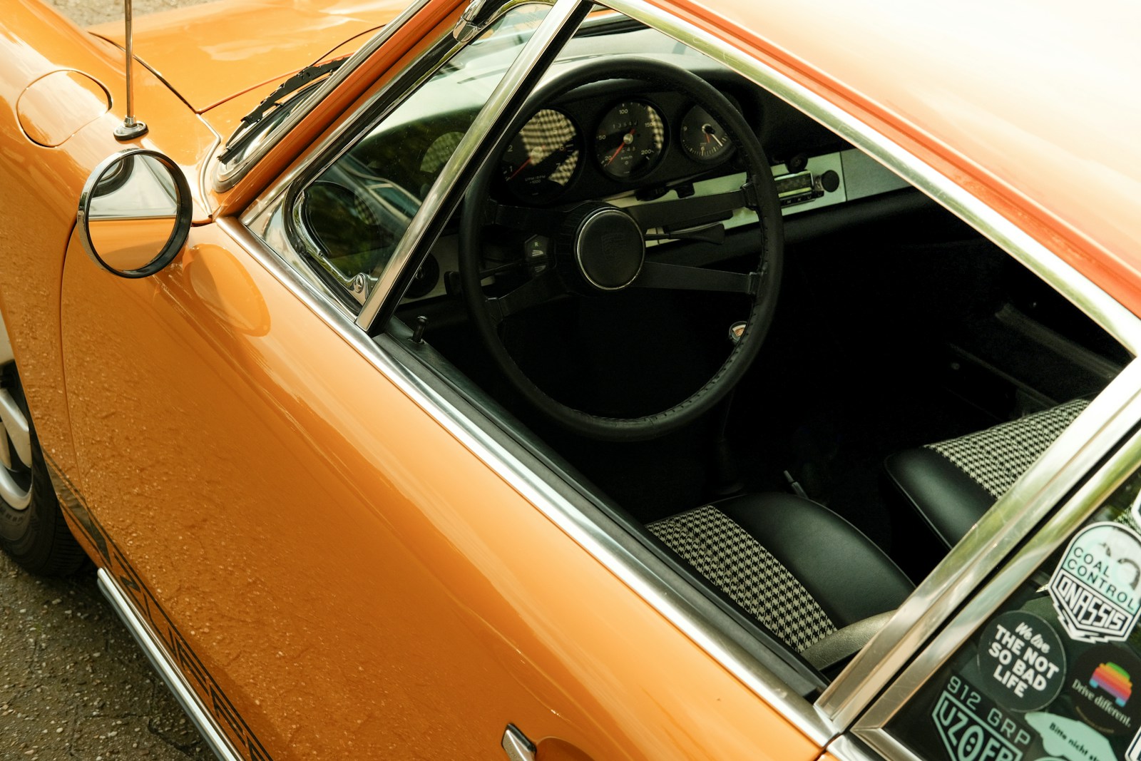 An orange car parked on the side of the road